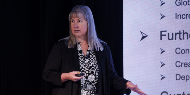 Jennifer McNealy delivers insights during a presentation session at an ACT Research seminar, sharing expertise on transportation industry trends and market developments.