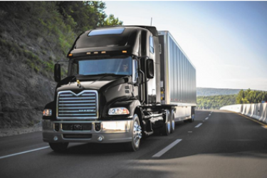 black semi truck on a curved road in smokey mountains