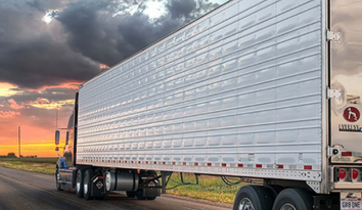 Truck with trailer driving left with scenic background