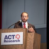 Tim Denoyer Speaking on stage at a seminar at the Commons