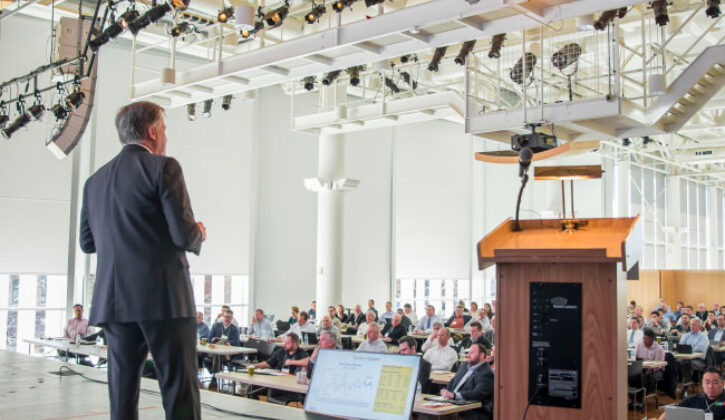 Kenny Vieth speaking on stage for the seminar at the Commons. View from behind Kenny facing the crowd.